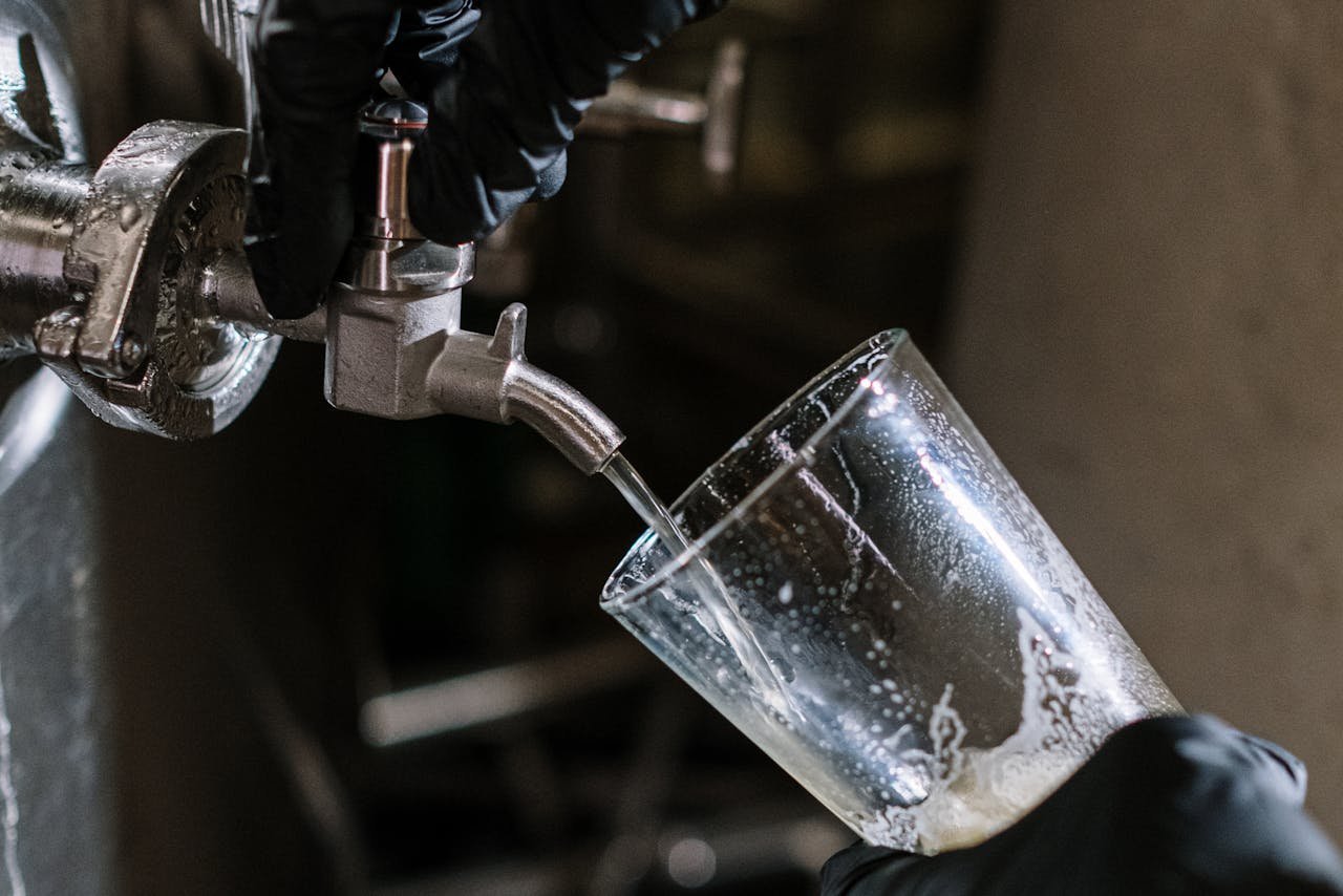 Steady stream of amber craft beer being poured from a tap into a clean pint glass