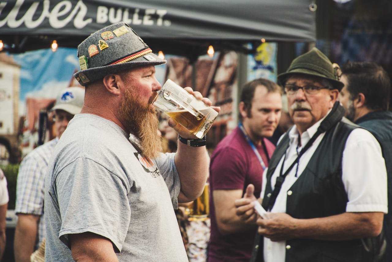 Large outdoor festival crowd gathered under clear skies with beer tents in the background